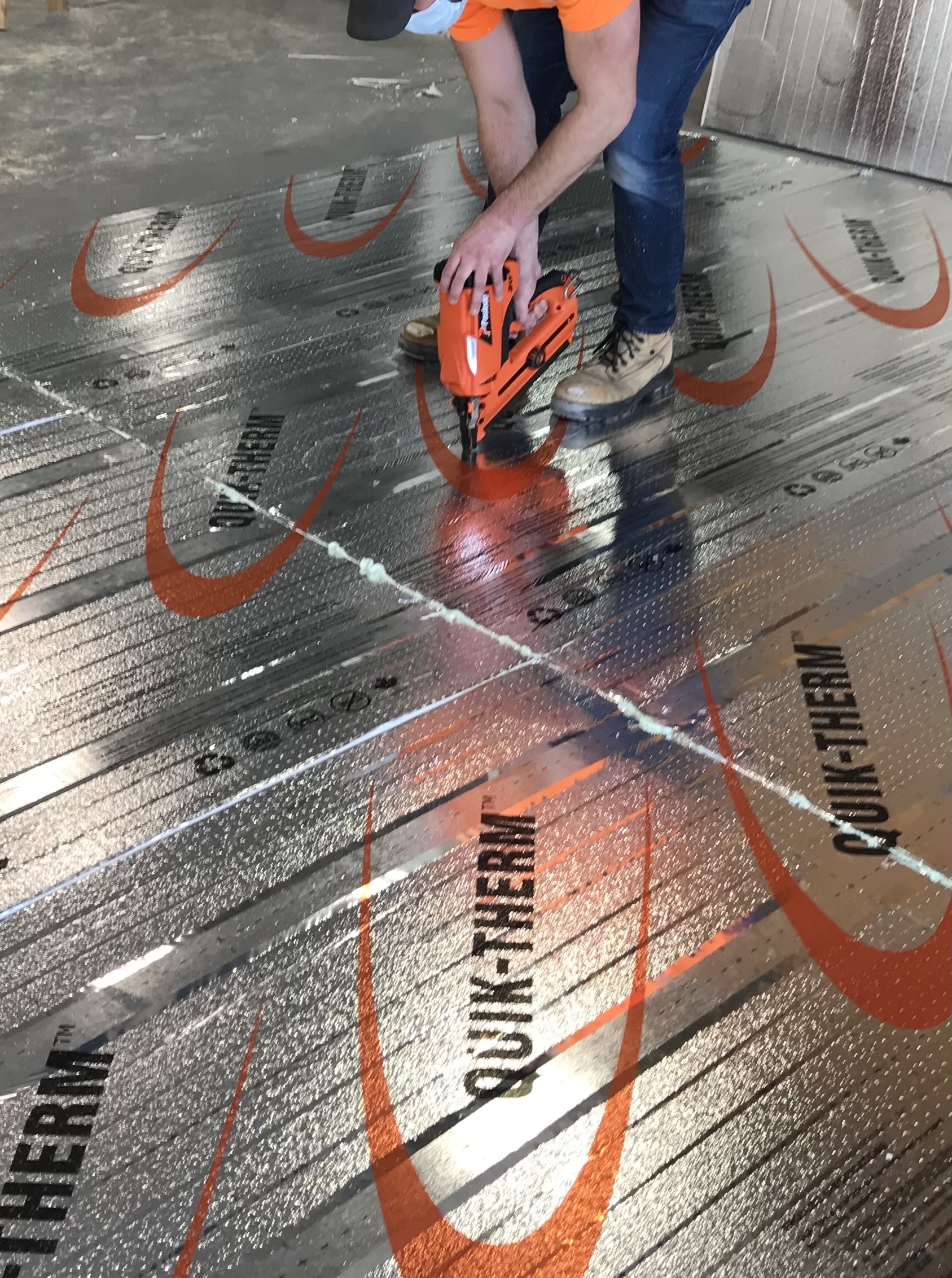 Person fastening insulation to framing