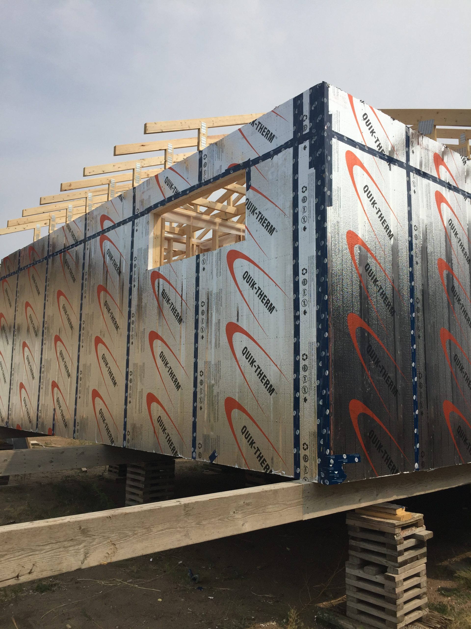 Person fastening insulation to framing