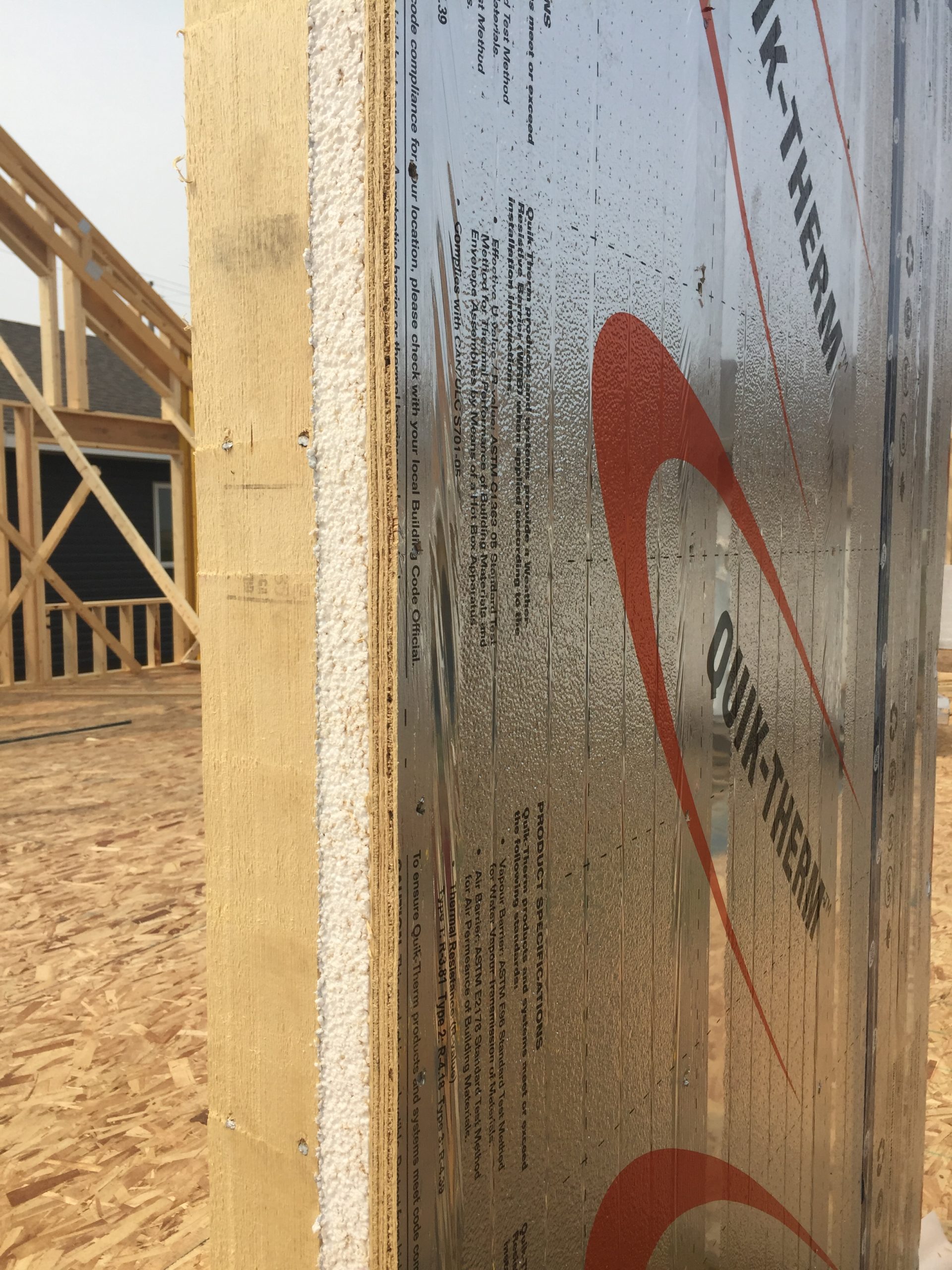 Person fastening insulation to framing