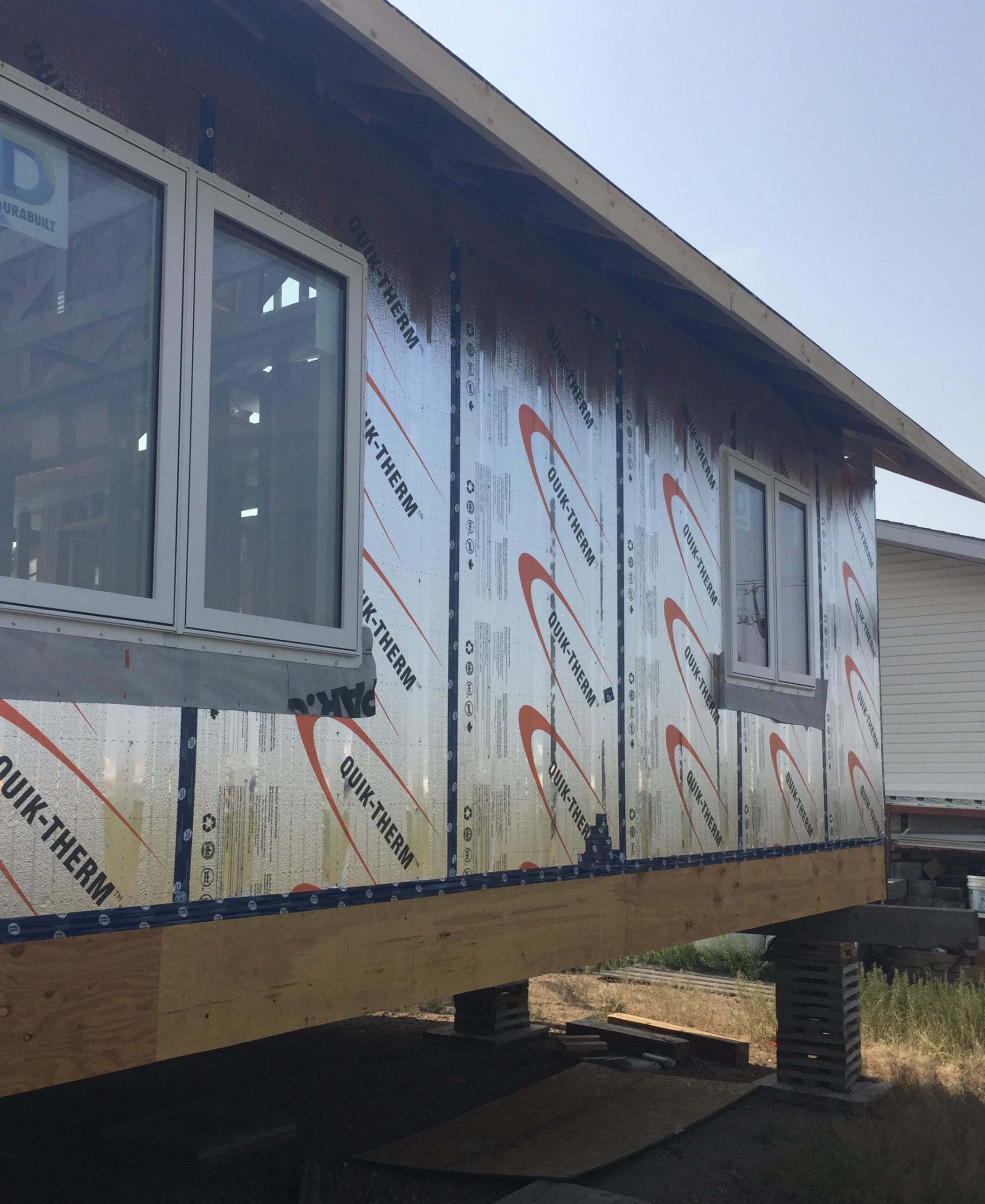 Person fastening insulation to framing