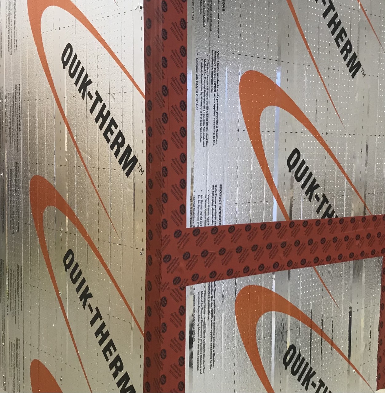 Person fastening insulation to framing