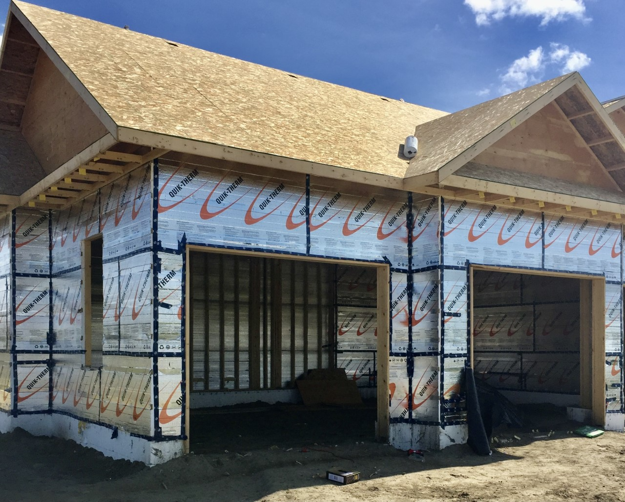Person fastening insulation to framing