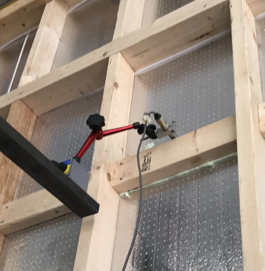 Person fastening insulation to framing